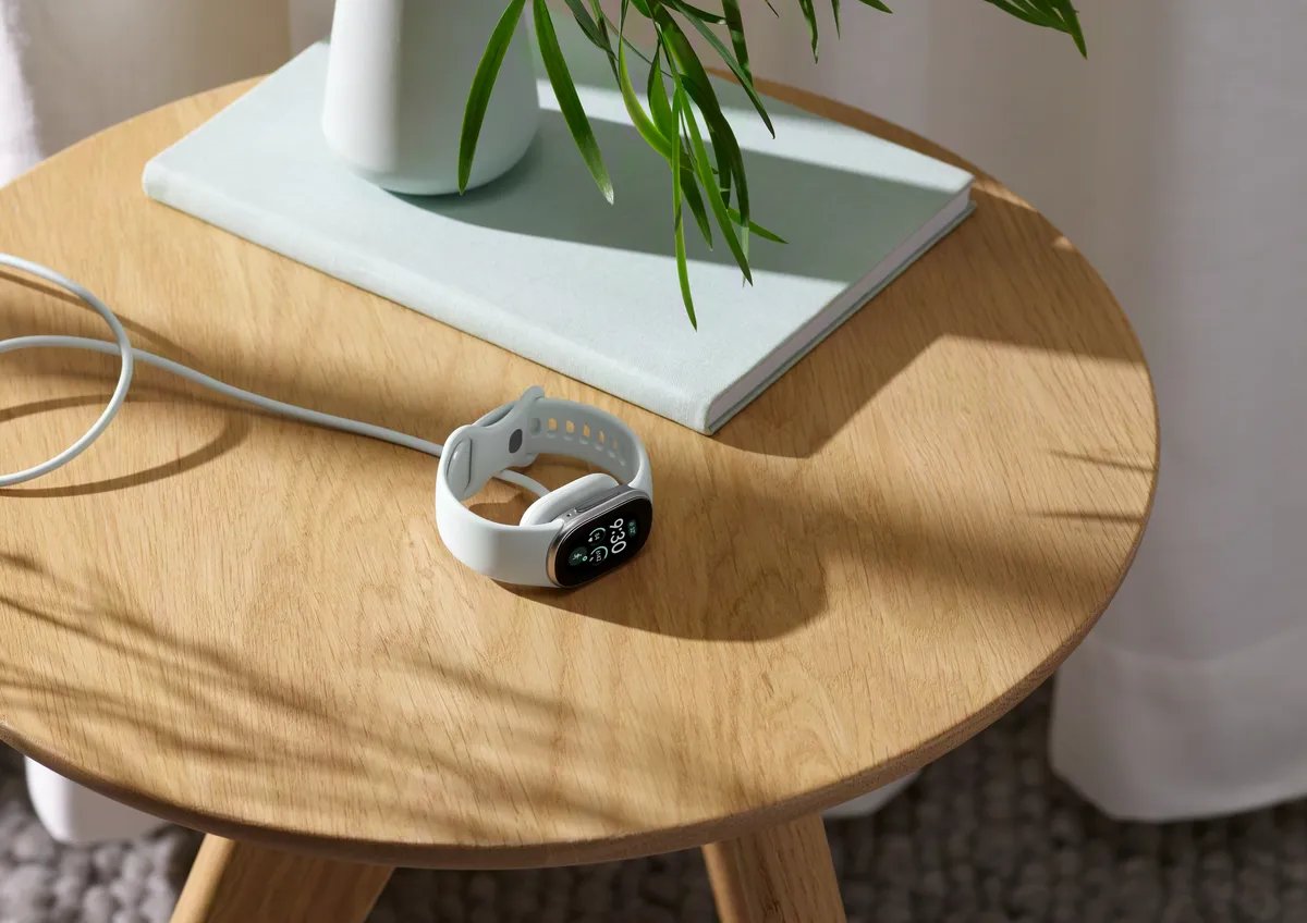 Fitbit Edge charging on a bedside table