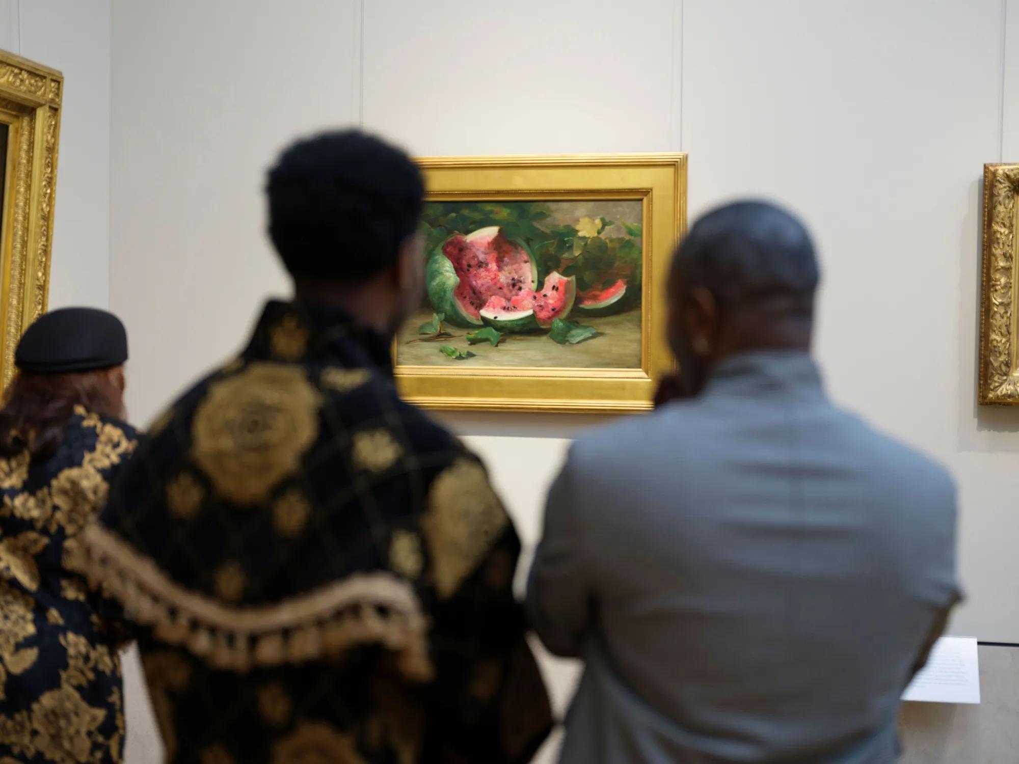 Visitors viewing a framed watermelon still-life at LG’s Beyond the Gallery event.