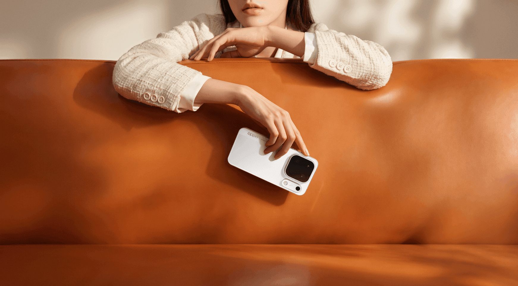 Person holding the Luna White OPPO Find X10 Pro Max beside an orange sofa