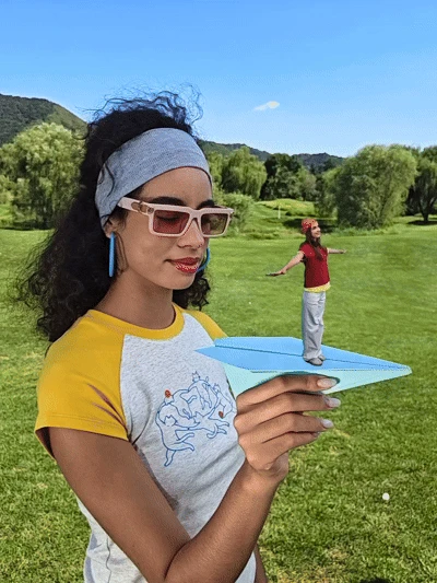 Manufacturer-edited example places a miniature person on a paper plane held by another person
